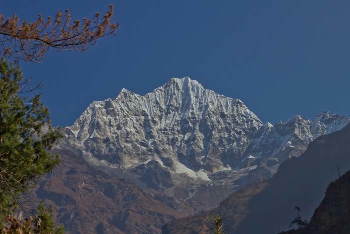 Everest Base Camp Day 2 - Kong De appears, framed by pines.