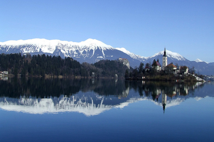 Lake Bled, Slovenia, with snow capped mountains reflected in the waters.